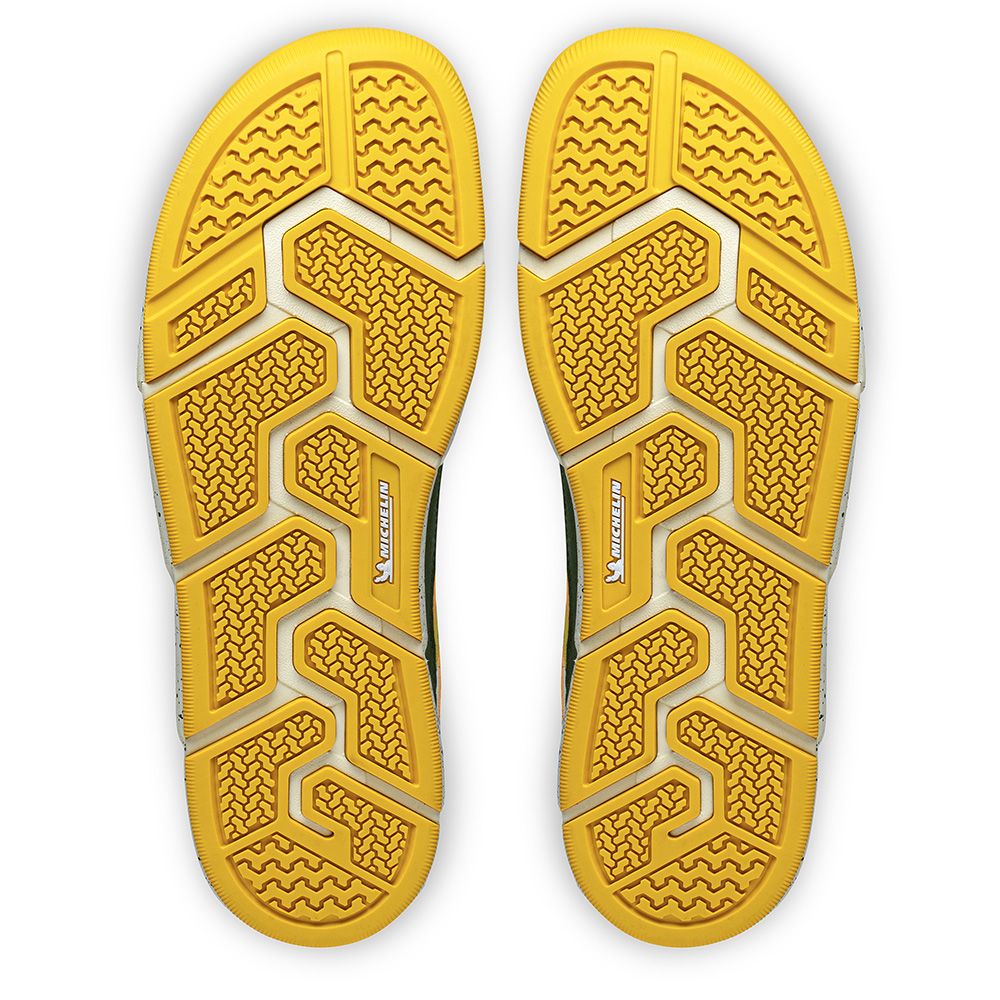 Undersida av Joe Nimble Addict barfotasko i färgen grön/gul, med gul yttersula i slitstarkt Michelin-gummi. Sulmönstret har flera flexzoner och greppsegment för stabilitet, grepp och naturlig fotrörelse vid gång och löpning.